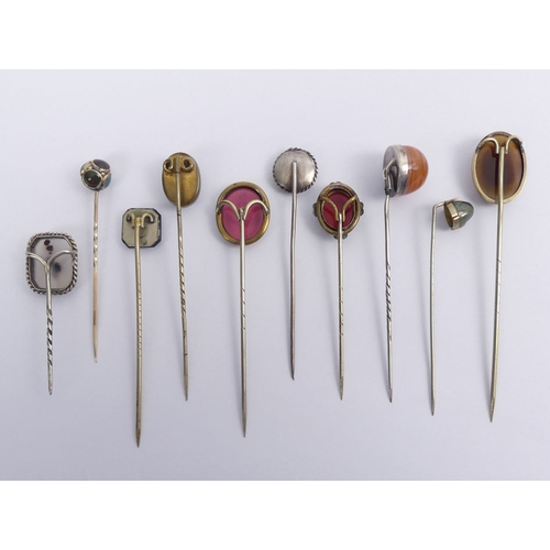 61 - Ten agate set stick pins, including a moss agate example and a Foresters example, longest 88mm.