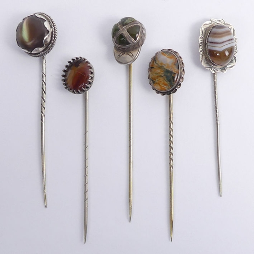 71 - A silver and agate jockey cap stick pin, Birm. 1893, along with four silver and agate examples, jock... 