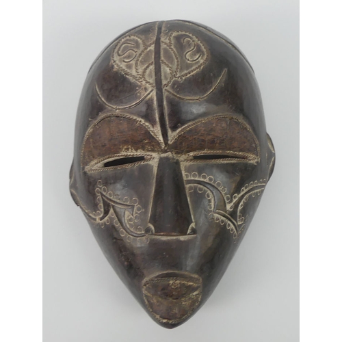 466 - A carved Cameroon Tikar tribal mask, 30cm x 21cm.