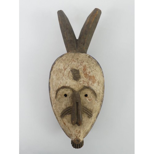 468 - A carved Nigerian Igbo tribal mask, 37cm x 14cm.