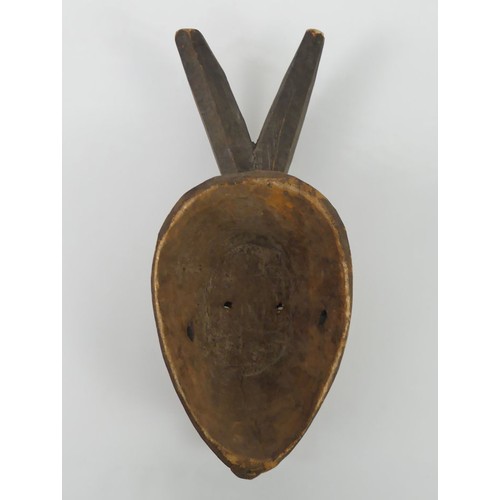 468 - A carved Nigerian Igbo tribal mask, 37cm x 14cm.