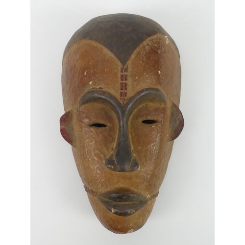 476 - A carved Ibibio tribal mask, 36m x 20cm.