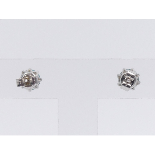 59 - A pair of 9ct white gold, blue topaz stud earrings, 2.2 grams, 7.1mm diameter.