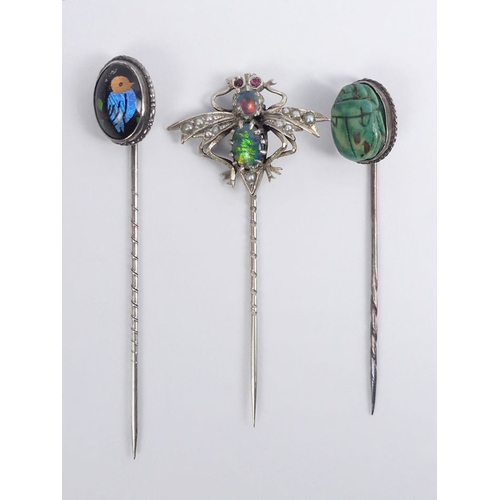 86 - A silver stone set bug design stick pin, along with a butterfly wing example and a scarab beetle exa... 