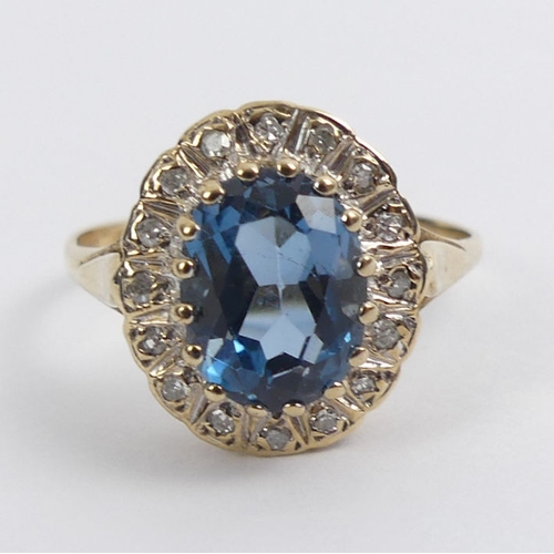 91 - 9ct gold, blue topaz and diamond ring, 2.8 grams, 13.6mm, size M.