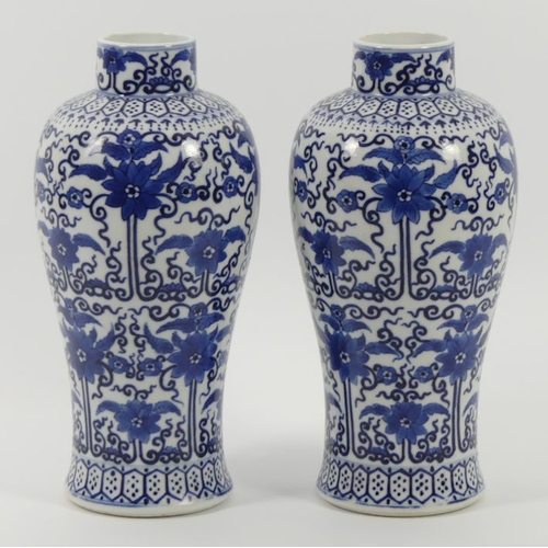 365 - A pair of late 19th century blue and white Chinese vases with floral designs, 27cm.