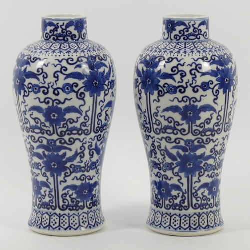 365 - A pair of late 19th century blue and white Chinese vases with floral designs, 27cm.