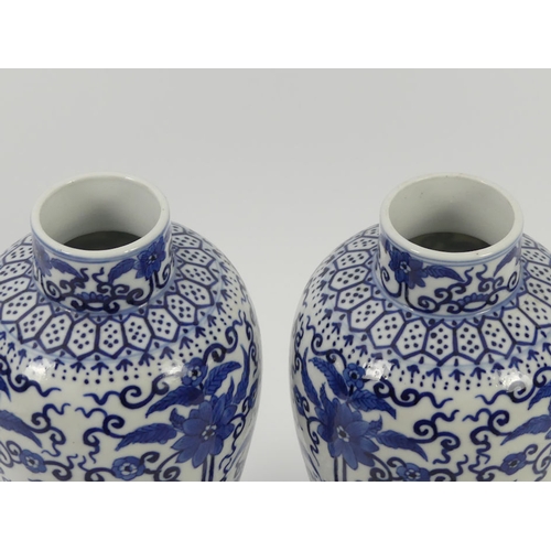 365 - A pair of late 19th century blue and white Chinese vases with floral designs, 27cm.