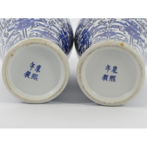 365 - A pair of late 19th century blue and white Chinese vases with floral designs, 27cm.