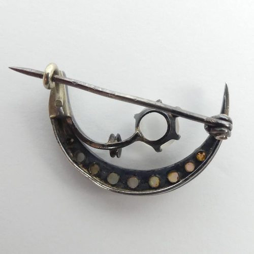 32 - A Victorian sterling silver moonstone and opal crescent brooch, 2.6 grams, 25mm.