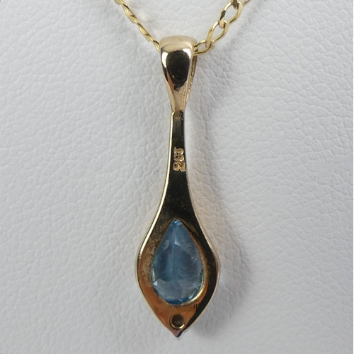 42 - 9ct gold, blue topaz and diamond pendant and chain, 2.1 grams.