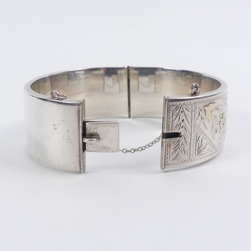 46 - Silver, with gilt metal decoration floral hinged bangle, Chester 1959, 35.1 grams, 22.5mm.