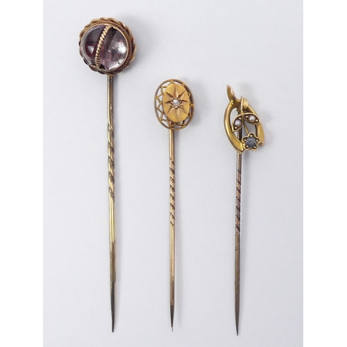 79 - Three gold topped stick pins, one set with a diamond, largest 12.5mm diameter.