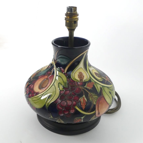 336 - A Moorcroft lamp base, decorated in the 'Queens Choice' pattern, fitted with a wooden base, 30cm.