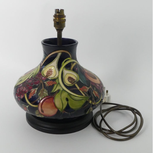 336 - A Moorcroft lamp base, decorated in the 'Queens Choice' pattern, fitted with a wooden base, 30cm.