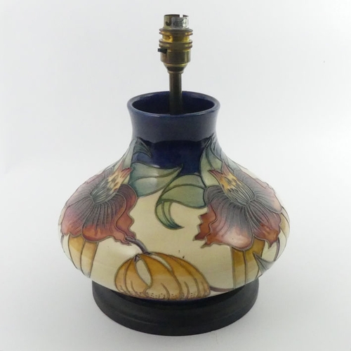 360 - A Moorcroft lamp base, decorated in the Anna Lily     pattern, fitted with a wooden base, 33 cm.