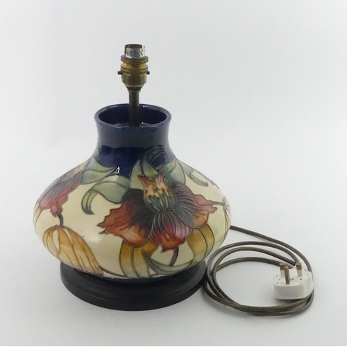 360 - A Moorcroft lamp base, decorated in the Anna Lily     pattern, fitted with a wooden base, 33 cm.