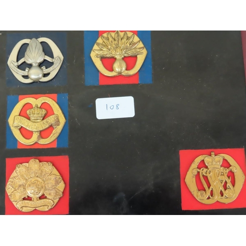 108 - Eighteen 20thC European Armies cap / Helmet badges mounted on boards