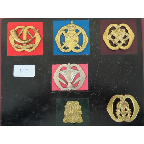 108 - Eighteen 20thC European Armies cap / Helmet badges mounted on boards