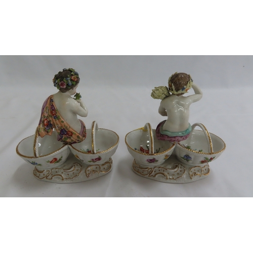 176 - Pair of Meissen style porcelain bonbon dishes in the form of putti, each sitting on the edges of two... 