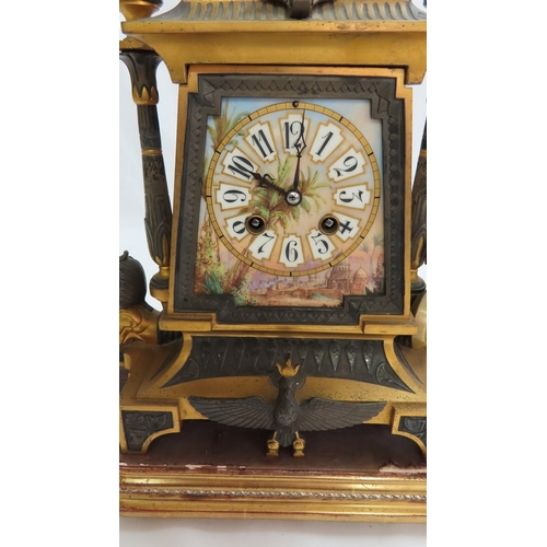 180 - A 19thC French ormolu and bronze mantel clock with Egyptian decoration, porcelain dial chiming on a ... 