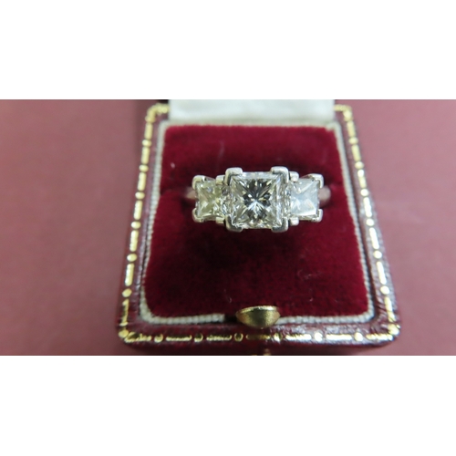 196 - A platinum princess-cut three stone diamond ring 2.43 carat. The central diamond assessed at 1.00 ca... 