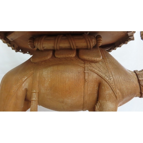 202 - An Anglo-Indian carved teak occasional table modelled as a camel, circa 1900. The octagonal top and ... 