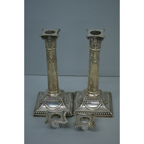 3 - Pair of GV loaded silver column candlesticks with decoration of swags, on square bases. Sheffield 19... 