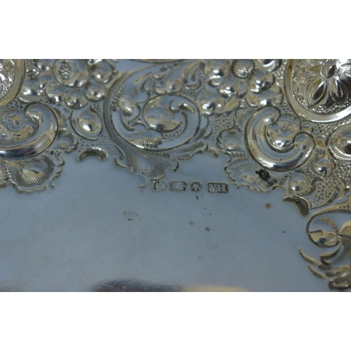 34 - A Victorian chased silver bread dish of shaped oval form with floral, C scroll and shell decoration.... 