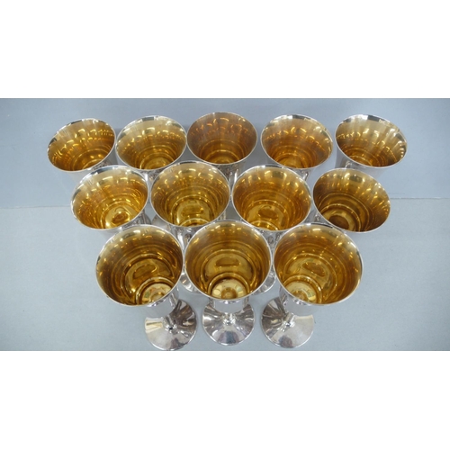 51 - A set of twelve silver gilt wine goblets with flared tops, bark stems and circular foot - Birmingham... 