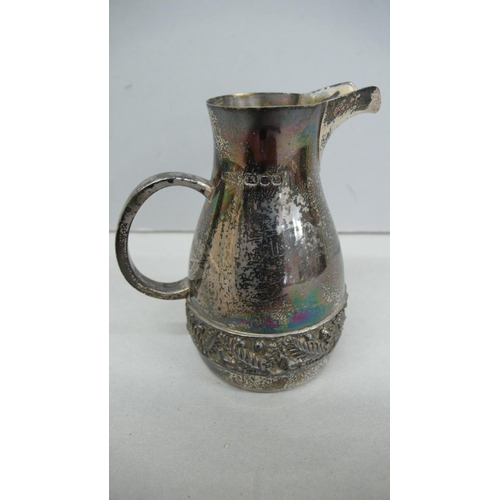 56 - A designer silver cream jug with decoration of of a belt of acorns, oak leaves, fearns and toad stoo... 