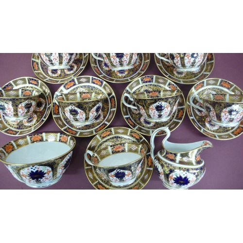 112 - A set of twelve Royal Crown Derby Imari pattern tea cups, saucers, milk jug and sugar basin - dated ... 