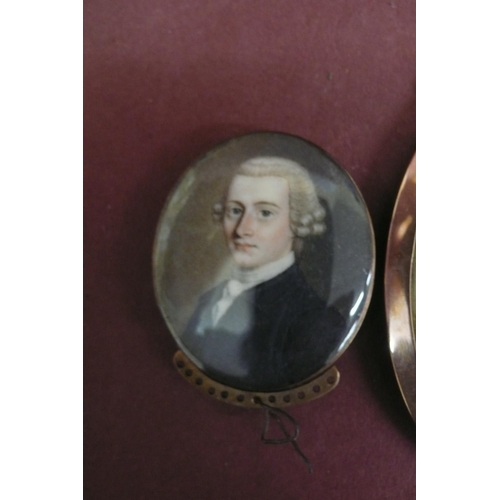 163 - Three well painted Georgian oval miniatures of men set in gold frames - largest ht. 2.6 ins