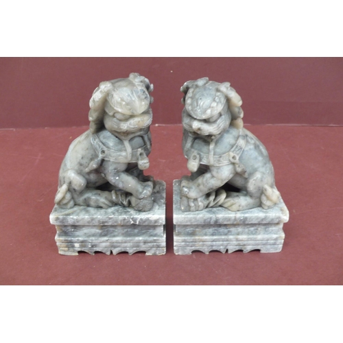 179 - Pair of Chinese carved grey figured soap stone lion dogs on pedestals - height 5.5ins