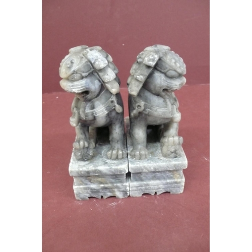 179 - Pair of Chinese carved grey figured soap stone lion dogs on pedestals - height 5.5ins