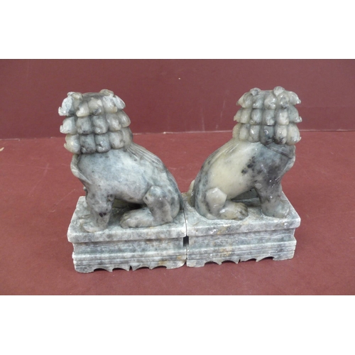 179 - Pair of Chinese carved grey figured soap stone lion dogs on pedestals - height 5.5ins