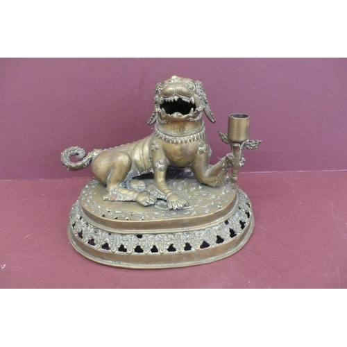 220 - 19thC Oriental brass lion dog holding a torch on a pedastal height 8.5, width 10.5ins