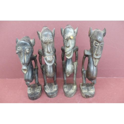 221 - Four 19thC African carved wooden grotesque figures height 8.5ins