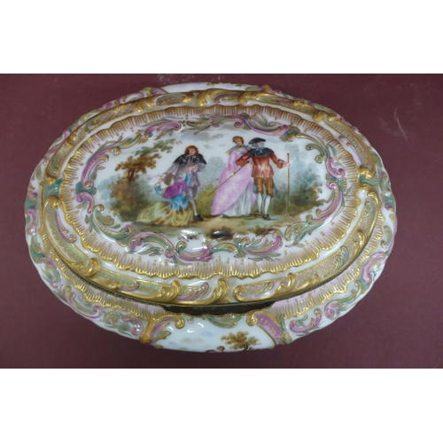 231 - An oval porcelain box with ormolu fittings having painted and transfer scene to top and sides of fig... 