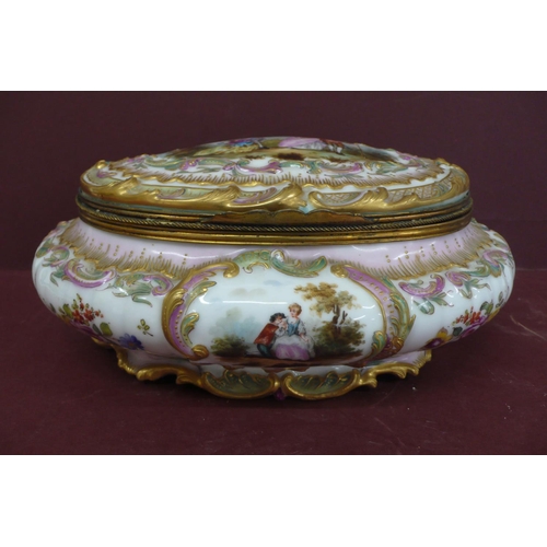 231 - An oval porcelain box with ormolu fittings having painted and transfer scene to top and sides of fig... 