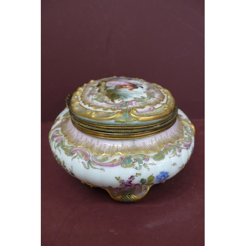 231 - An oval porcelain box with ormolu fittings having painted and transfer scene to top and sides of fig... 