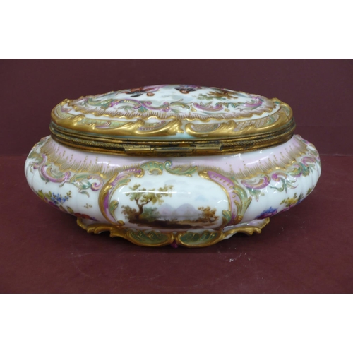 231 - An oval porcelain box with ormolu fittings having painted and transfer scene to top and sides of fig... 