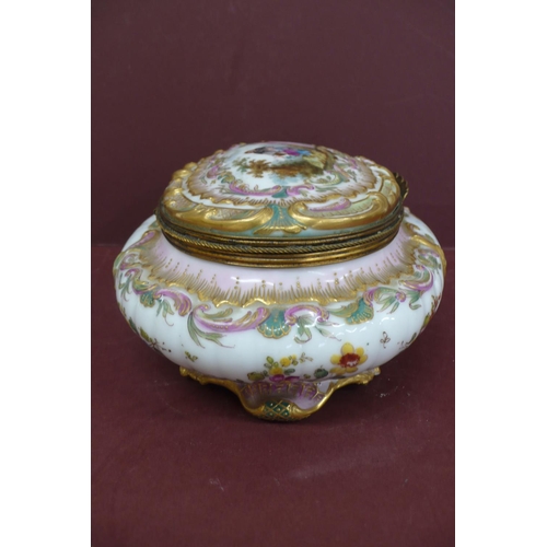 231 - An oval porcelain box with ormolu fittings having painted and transfer scene to top and sides of fig... 