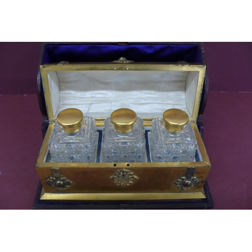 275 - A Victorian quality ormolu casket holding three hobnail cut clear glass bottles, the casket adorned ... 