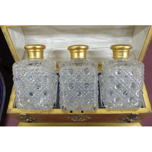 275 - A Victorian quality ormolu casket holding three hobnail cut clear glass bottles, the casket adorned ... 