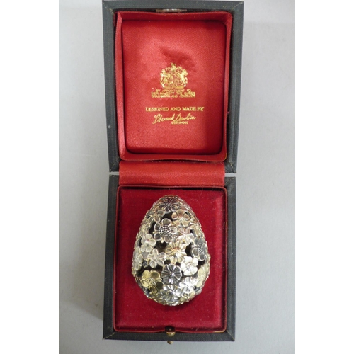 306 - Stuart Devlin parcel gilt silver egg ornament, with pierced floral exterior opening to reveal an ibi... 