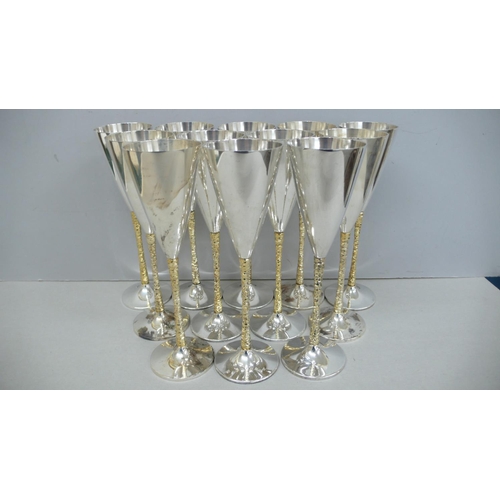 58 - A dozen Stuart Devlin parcel gilt silver champagne goblets with conical tops bark stems and circular... 