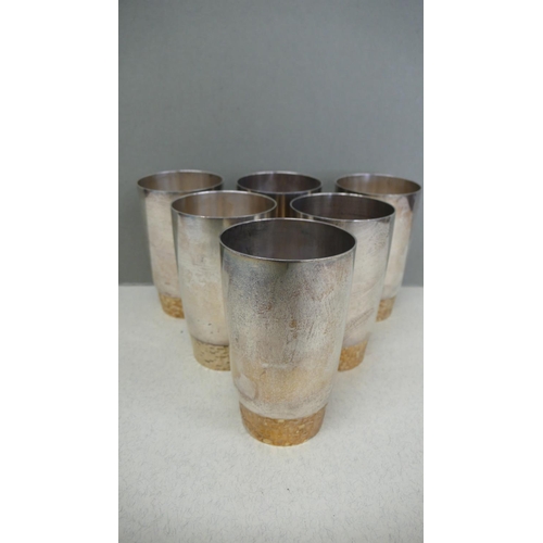 65 - A set of six Stuart Devlin parcel gilt silver beakers with bark decoration to the lower fifth of bod... 