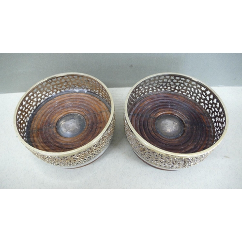 66 - A pair of Stuart Devlin parcel gilt silver and hardwood bottle coasters with pierced borders and sil... 