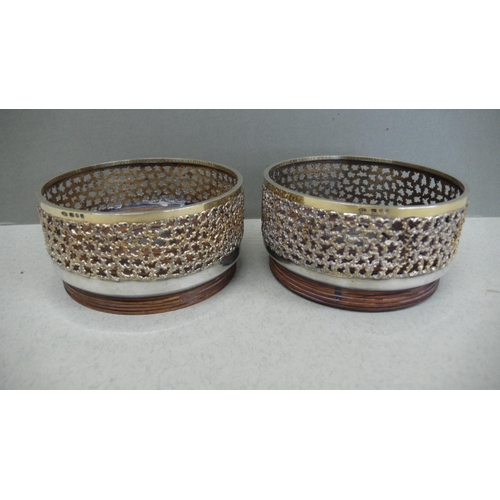 66 - A pair of Stuart Devlin parcel gilt silver and hardwood bottle coasters with pierced borders and sil... 